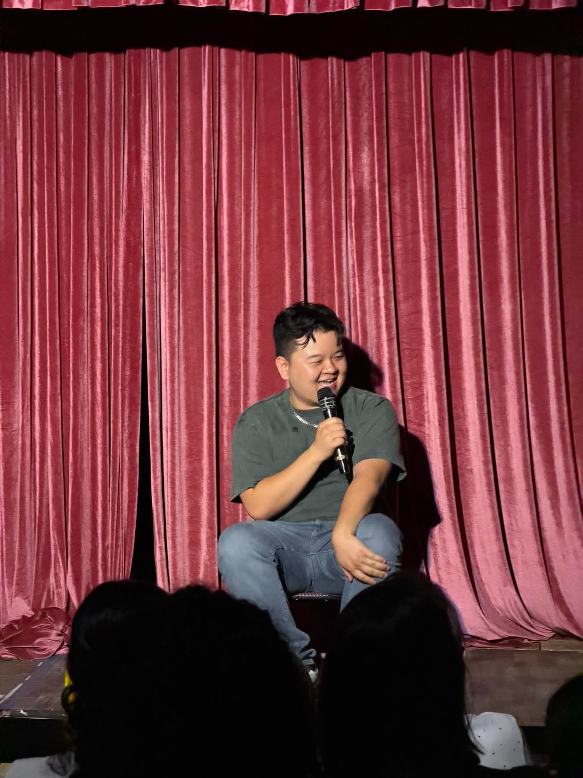 Will Pepper sitting on the edge of the stage, talking to the front row